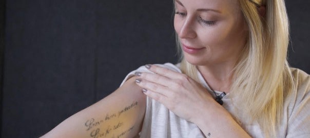 woman with tattoo thinks How Much Does Laser Tattoo Removal Cost