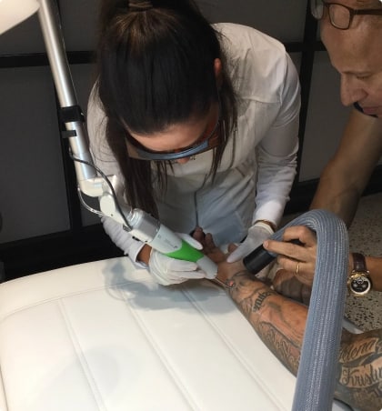 Tattoo Removal of mans armed tattoo 2 specialists working
