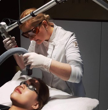 tattoo laser removalist about to remove tattoo on head of woman